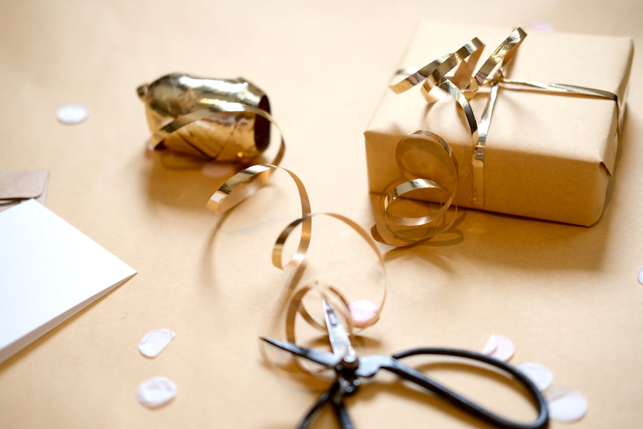Brown paper gift with gold ribbon and scissors. Perfect for holiday or birthday wrapping inspiration.